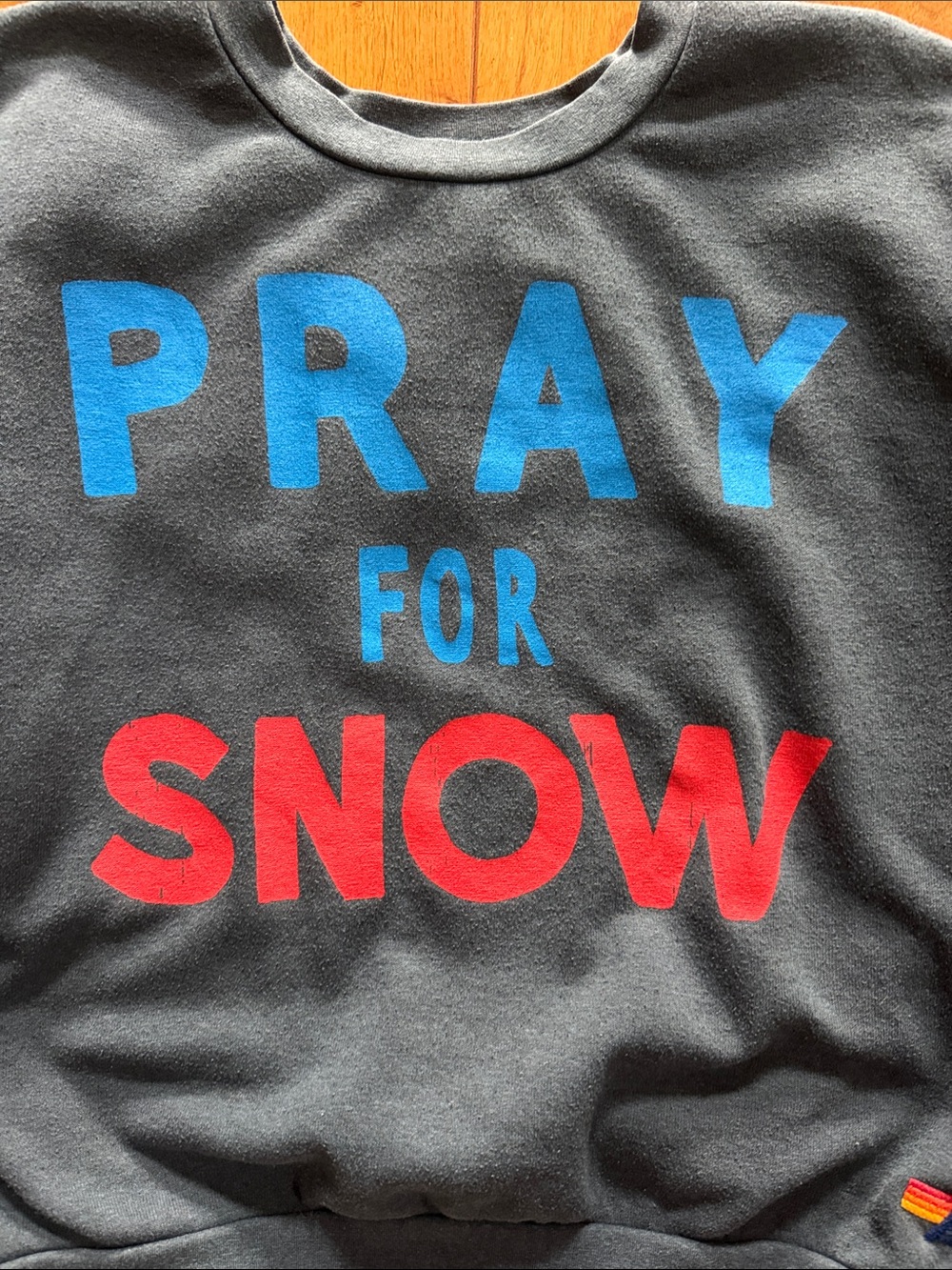 “Pray for Snow” Charcoal Graphic Sweatshirt with Blue & Red Lettering